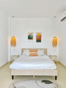 芹苴LASAOMA HOMESTAY的一间卧室配有带白色床单和橙色枕头的床。