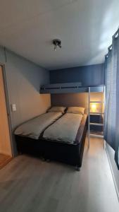 特罗姆瑟Arctic Lodge Tromvik with jacuzzi的一间卧室配有一张蓝色墙壁的床