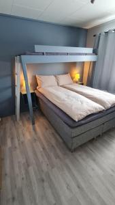 特罗姆瑟Arctic Lodge Tromvik with jacuzzi的一间卧室设有一张床和蓝色的墙壁