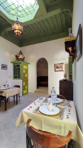 马拉喀什RIAD DAR En-Nawat的一间带桌椅的用餐室和一间房间