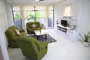 乔治市Isabella Villa George Town Penang的客厅配有两张绿色椅子和一张桌子