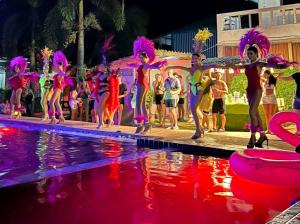 哈林海滩WET! a Pool Party Hostel by Wild & Wandering的一群人晚上在泳池边跳舞
