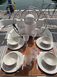 里斯本Sea Bloom - Sleep & Sail in Tejo的船上的桌子,上面有盘子和酒杯