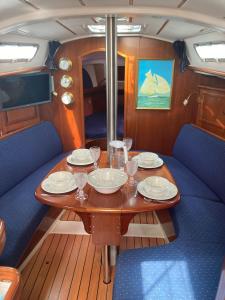 里斯本Sea Bloom - Sleep & Sail in Tejo的船上的木桌,带盘子和酒杯