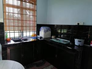 巴佐SMART 2.0 Homestay Pantai Kemayang Bachok的厨房配有黑色台面和水槽