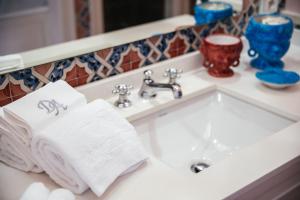 圣安格塔苏德格尔夫顿阿尔丰索1890精品酒店的浴室水槽和台面上的毛巾