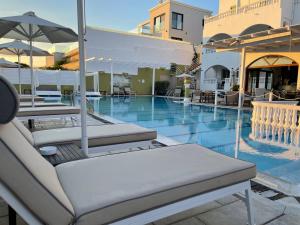 圣斯特凡诺斯Fedra Mare的一个带躺椅和遮阳伞的游泳池