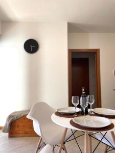 佩鲁贾Filo Guest House的一张桌子、两把椅子和两杯酒杯