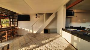 普拉杜Bangalô Aconchegante de Frente para o Mar的一间带一张床的卧室,位于带楼梯的房间