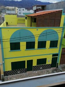 波多诺伏Residencial Chez Flor的黄色和蓝色的建筑,设有绿门