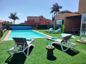 萨洛夫雷Villa Lía by SunHousesCanarias的一个带两把椅子的庭院和一个游泳池