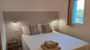 圣海梅-德恩韦哈Mas Midó的卧室配有白色的床和毛巾