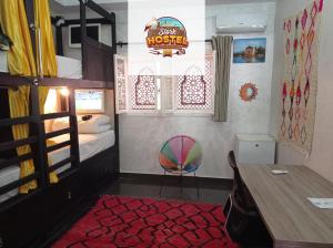 马拉喀什Stork Marrakech Luxury Hostel的一间卧室配有一张双层床、一张桌子和一把椅子