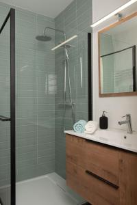 夏蒙尼-勃朗峰Charmant Studio tout confort au Brévent-Chamonix的带淋浴、水槽和镜子的浴室