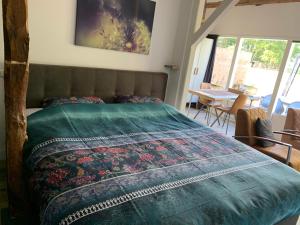 SinderenGastenverblijf 't Oelengoor的一间卧室配有一张带绿色棉被的床