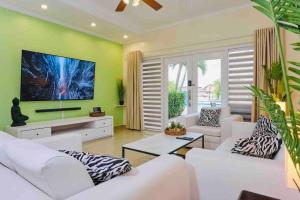 棕榈滩Eagle Beach Aruba Breeze Condominium Lime的客厅配有白色家具和绿色墙壁。