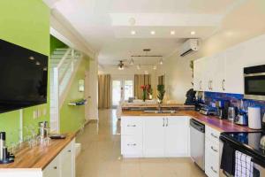 棕榈滩Eagle Beach Aruba Breeze Condominium Lime的一间设有白色橱柜和绿色墙壁的大厨房