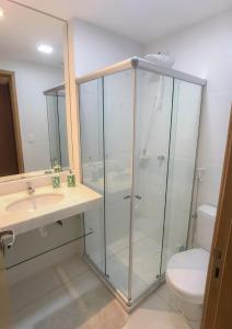 瓜拉久巴Flat Guarajuba, Charmoso Porto Smeralda的一间带玻璃淋浴和卫生间的浴室