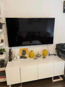 安特卫普Modern apartment with garden in Antwerp, 15min from City center的白色橱柜上的大屏幕平面电视