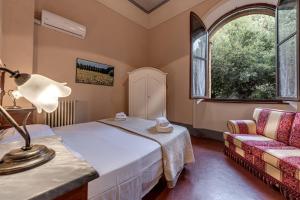 渥尔特拉Appartamenti Villa Mascagni的一间卧室配有一张床和一张沙发