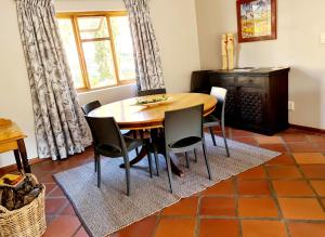KlaarstroomAngelierbosch Guest House的一间带木桌和椅子的用餐室