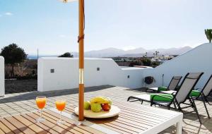 蒂亚斯Typical Canarian house with fabulous sea views的一张桌子,上面放着两杯橙汁和水果