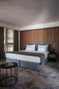 杜布罗夫尼克City Hotel Dubrovnik的一间卧室配有一张大床和一张桌子