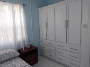 卡斯特里Vee's Apartments SLU的卧室配有白色橱柜、一张床和一个梳妆台