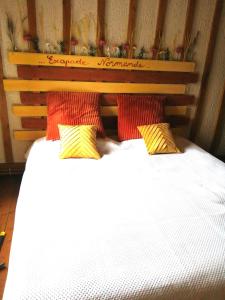 YervilleEscapade Normande SPA的一间卧室配有红色和黄色枕头的床