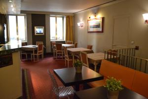 马赛圣弗雷奥尔酒店的用餐室设有桌椅和窗户。