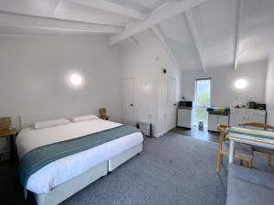 奥克兰午间小憩汽车旅馆的一间白色卧室,配有床和厨房