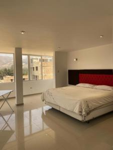 卡哈马卡Hotel Casa Blanca Huacariz的一间卧室配有一张大床和红色床头板