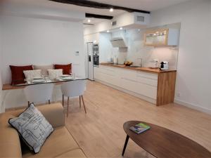 卢戈Apartamento con encanto en centro histórico Lugo -TineriaLucusHome的厨房以及带沙发和桌子的客厅。