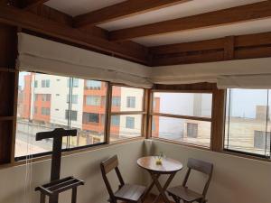 利马El Refugio de Barranco的客房设有桌椅和窗户。