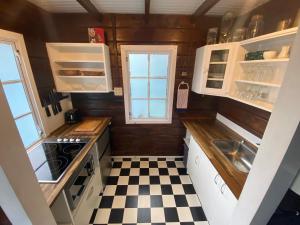派西亚Paihia Place Cottage - central Paihia的一间小厨房,配有白色橱柜和 ⁇ 格地板