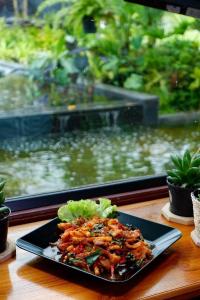 Ban Don Tum (1)Srihome ยายศรีโฮมแอนแคมป์ปิ้ง的鱼缸前桌子上的一盘食物