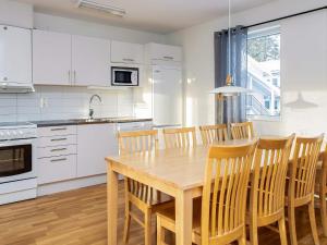 洛夫斯达伦Apartment LOFSDALEN V的厨房配有白色橱柜和木桌及椅子