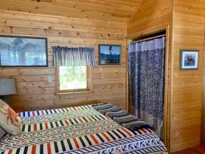 Clam GulchClam Gulch Lodge的小木屋内一间卧室,配有一张床