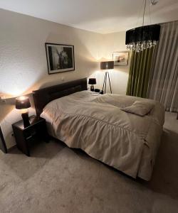 明登精美酒店的一间卧室配有一张大床和一张带台灯的桌子。