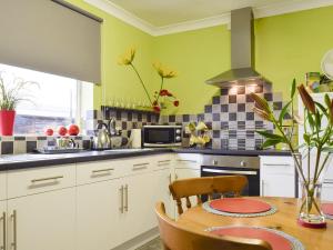 Birtsmorton莉娜山林小屋酒店的厨房设有绿色的墙壁和木桌