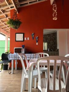 伯迪亚哥Pousada da Sú的一间带桌子和白色椅子的用餐室