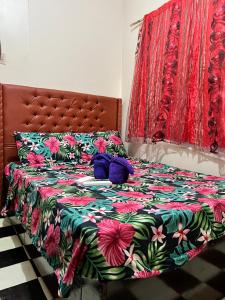 宿务May’s Homestay的一张带花卉床罩和紫色枕头的床