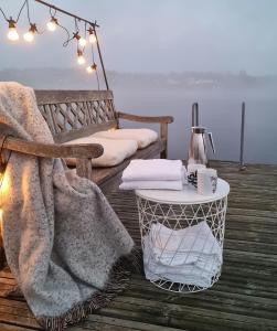 维克松Tyrifjord Hotell的一张桌子,上面有毯子,码头上还有一张床