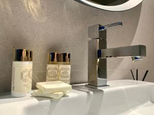 米兰德拉Ribeira House的浴室水槽配有水龙头和2瓶肥皂