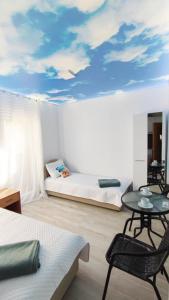 贝西奇Mini Candy central location Bečići的一间卧室配有一张床和一张天花板上彩绘天空的桌子。