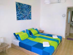 特鲁克巴库Ten RooMs的一间卧室配有蓝色和绿色的床