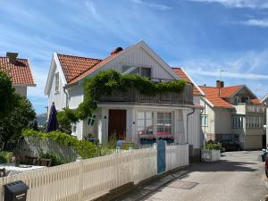 谢尔港Bekvämt boende mitt i gamla genuina Skärhamn的前面有栅栏的白色房子