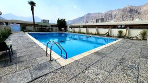 海塞卜海塞卜酒店的一个大型蓝色游泳池,后面是群山