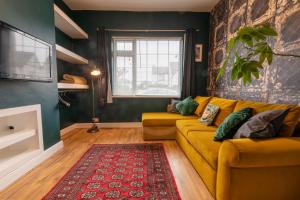 布里斯托3 bedroom home and garden in North Bristol的客厅配有黄色沙发和红色地毯