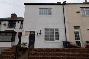 布里斯托3 bedroom home and garden in North Bristol的白色的房子,有黑色的门和窗户